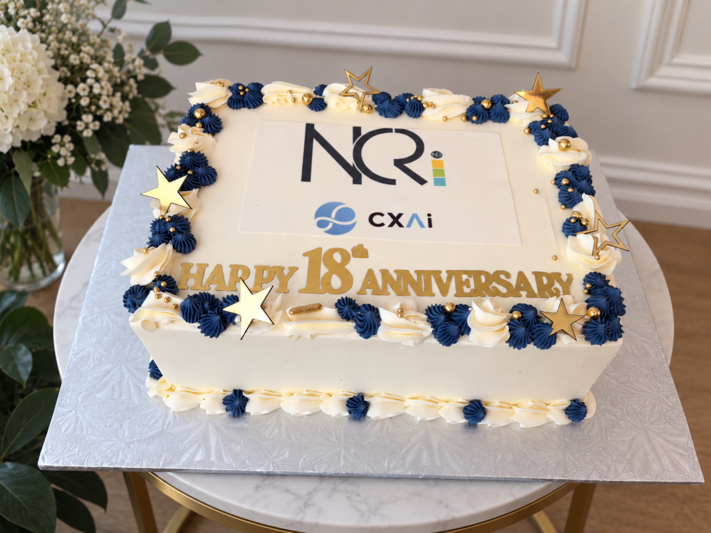 Gâteau d’anniversaire corporatif personnalisé à Montréal pour NCRi et CXAi, célébrant leur 18e anniversaire avec leurs logos et des décorations bleu marine, blanc et or